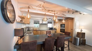 A modern kitchen with a central island, pendant lights, and wooden cabinetry. - Holiday home, Ile d'Oléron 'L'Eglade' 4 star rating * * * * (Le Grand-Village-Plage)