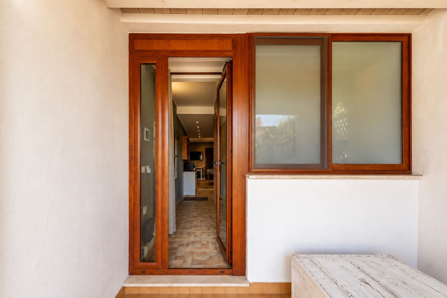 Un couloir avec une porte en bois donnant sur un espace cuisine.