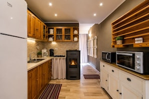 A modern kitchen with wooden cabinets, a built-in oven, a microwave, and a gas stove. - Detached house with a garden / 600 m from the sea, Southern Sardinia (Quartu Sant'Elena)