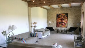 Een ruime woonkamer met een bank, een salontafel en een schilderij aan de muur.