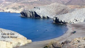 Cabo de Gata Playa de Monsul, een rotsachtige kustlijn en helderblauw water.