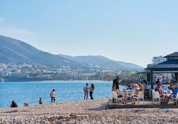Una playa cerca, sillas reclinables de playa, toallas de playa