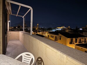 A balcony with a view of a cityscape at night, including buildings and a clock tower. - Historic center, 2 rooms, 2 toilets, sky terrace, lift, free high speed Wi Fi (PALERMO)