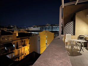 A rooftop terrace with a view of the cityscape at night, including buildings with illuminated windows and a modern structure with a glass facade. - Historic center, 2 rooms, 2 toilets, sky terrace, lift, free high speed Wi Fi (PALERMO)