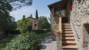 A stone building with a staircase leading up to a covered entrance.