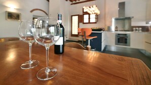 Uma mesa de jantar de madeira com dois copos de vinho vazios e uma garrafa de vinho.