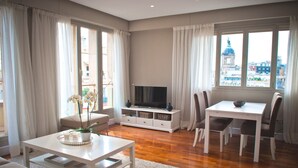 Un salon moderne avec un téléviseur, une table à manger et des chaises.