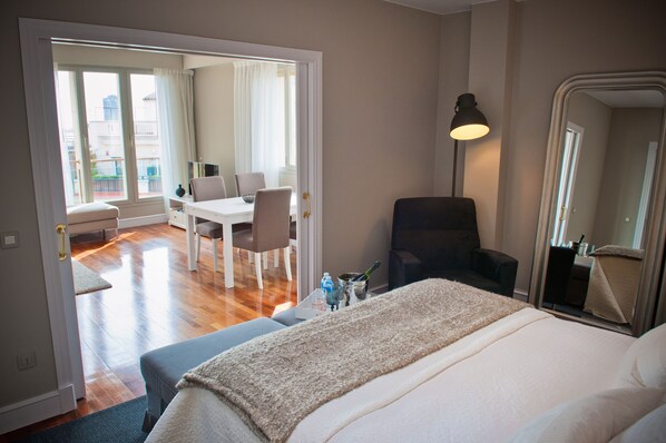Ein Hotelzimmer mit einem Bett, einem Sessel, einem Schreibtisch und einem großen Fenster.