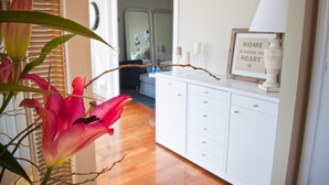 Une pièce avec un meuble blanc, un miroir et un panneau encadré accroché au mur.
