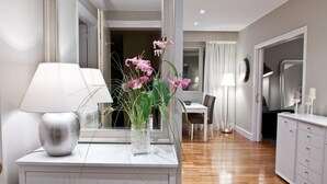 Une salle de bain moderne avec un meuble-lavabo blanc, un miroir et un vase contenant des fleurs roses.