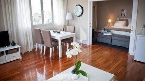 Un salon moderne comprenant un coin repas, un téléviseur et une orchidée en pot.