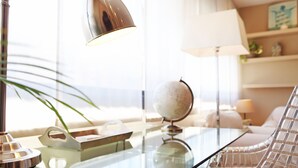 A modern living room with a glass coffee table, a globe, a lamp, and a chair. - Property with parking, Ac,wifi, metro & at only 8 min.from city centre by metro. (Barcelona)