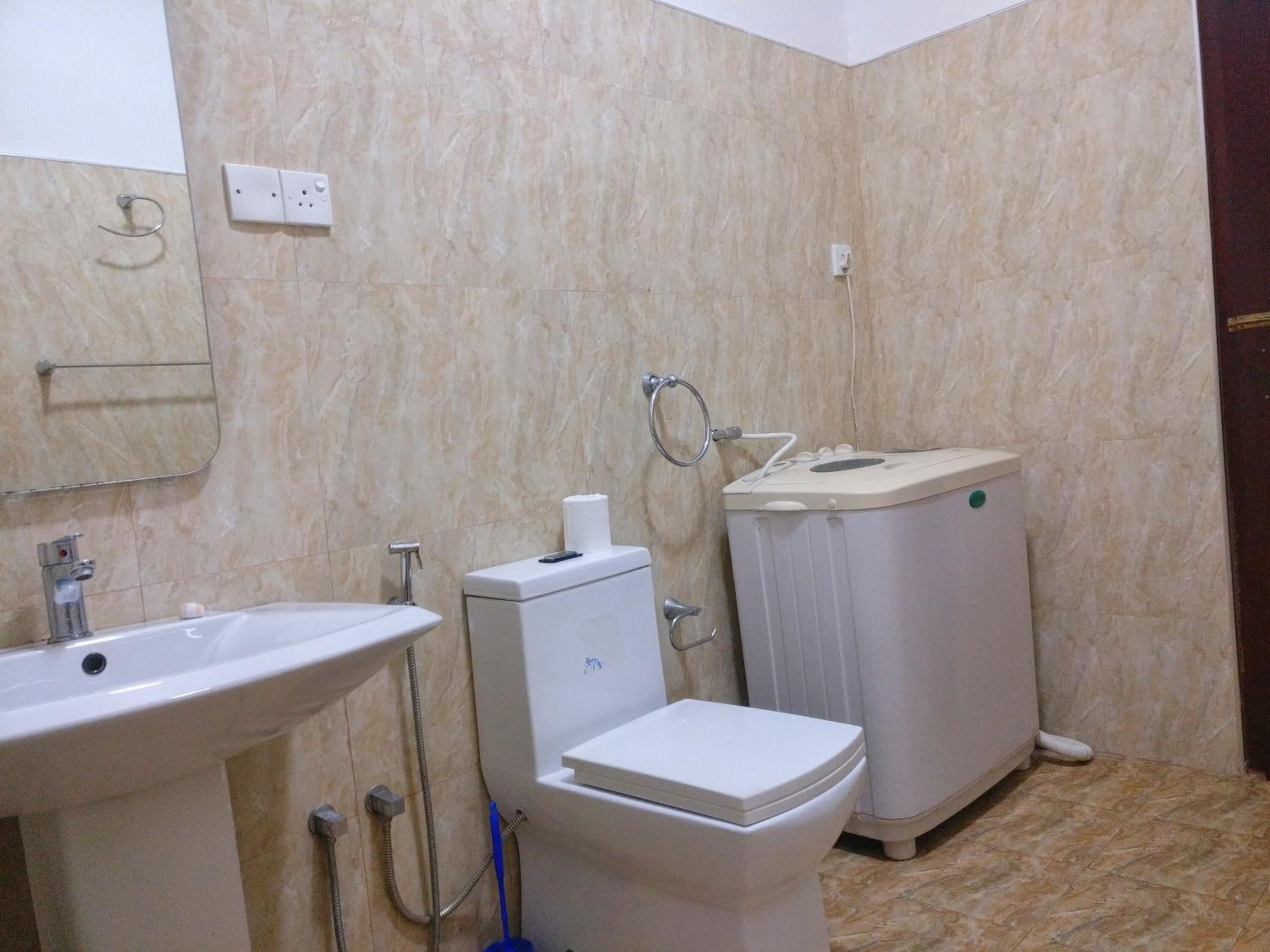 A bathroom with a sink, toilet, and bidet.
