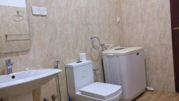 A bathroom with a sink, toilet, and bidet.