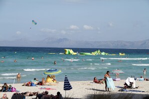 A beach with people swimming and sunbathing, umbrellas, and inflatable water toys. - Villa President - Cosmos. Villa with private pool and 500m from the beach (Muro)