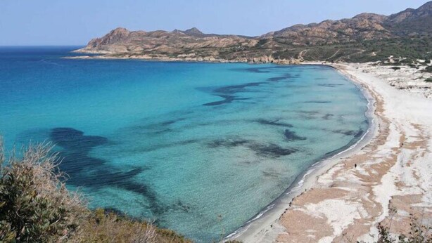 A coastal landscape with clear turquoise waters, sandy beach, and rocky hills in the background. - Pigna: Charming village house, 5 km from the sea, vaulted and whitewashed (Pigna)