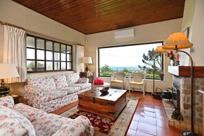 A cozy living room with a sofa, a coffee table, and a fireplace.