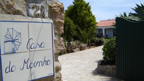 Un sendero de piedra que lleva a un edificio con un letrero que dice "Casa do Moinho".