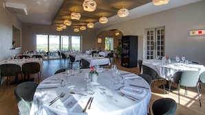 A restaurant with round tables set for dining, featuring white tablecloths and neatly arranged cutlery. - Hôtel Restaurant Le Meysset (Sarlat-la-Canéda)