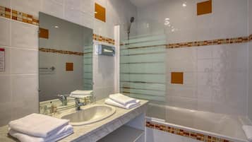 A bathroom with a sink, mirror, and shower.