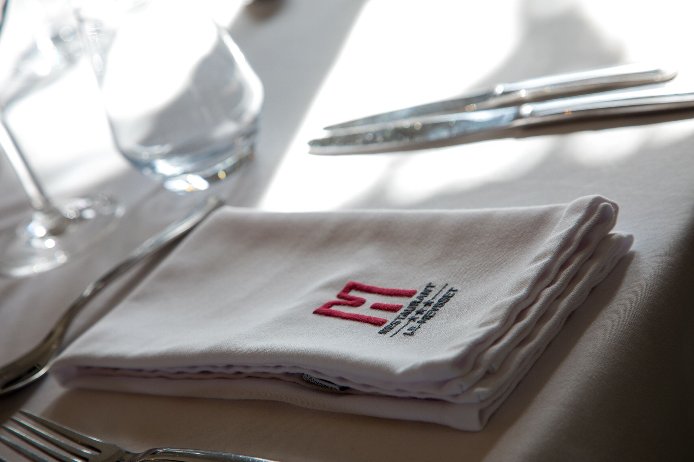 A neatly folded white napkin with a logo and text on a table.