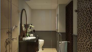 Un baño moderno con cabina de ducha de vidrio, un lavabo con espejo y un inodoro.
