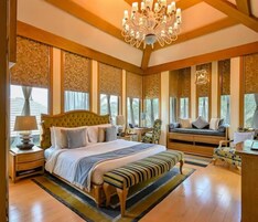 Un dormitorio amplio con una cama grande, un banco y un escritorio.