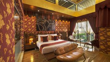 A spacious bedroom with a large bed, a leather sofa, and a dining area.