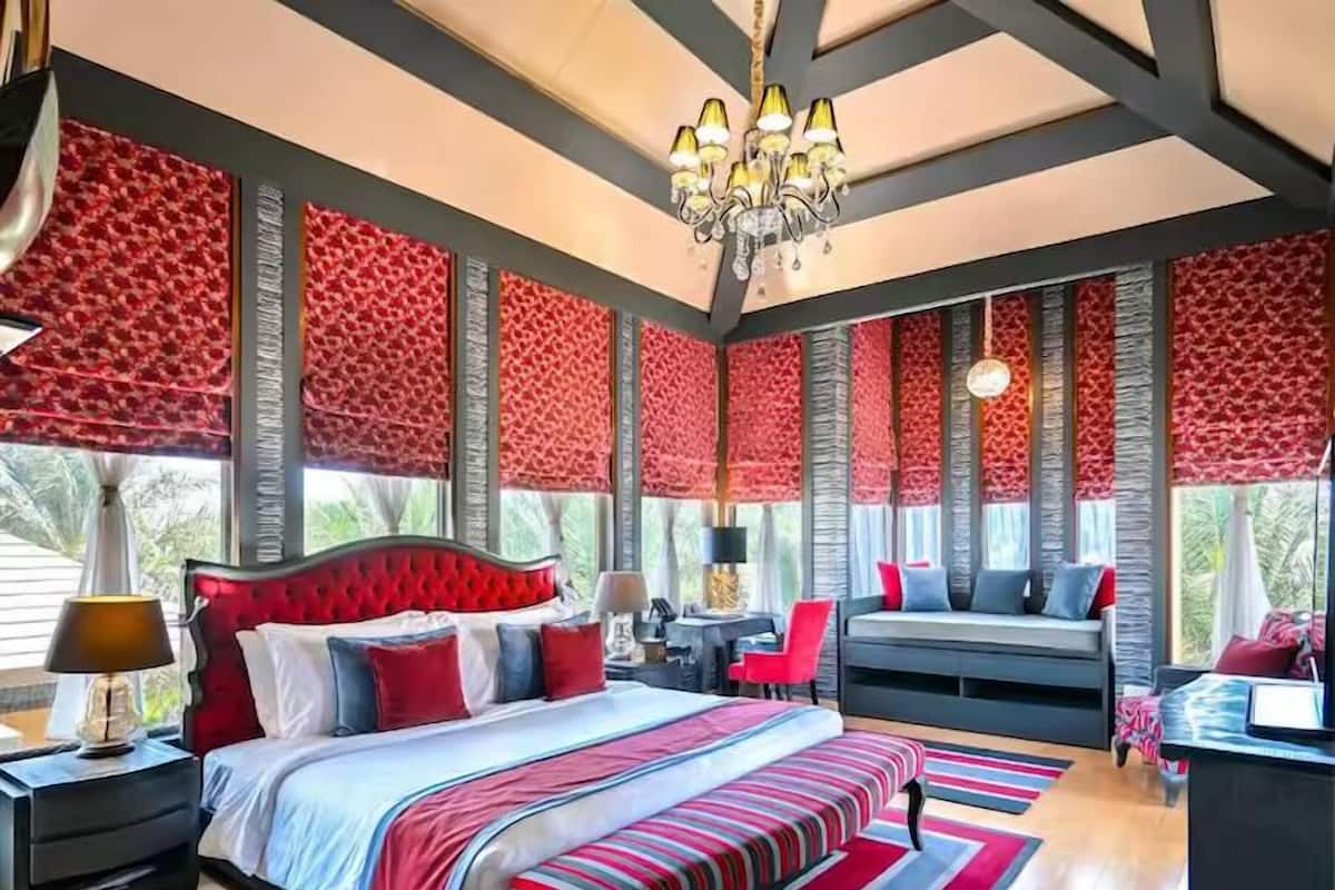 A modern bedroom with a large bed, a desk, and a sofa.