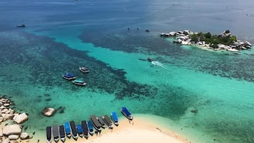 Pantai di sekitar, pasir putih, payung pantai, dan handuk pantai