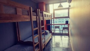A dormitory room with bunk beds, a small table, and a chair near a window. - Life Guesthouse - Hostel (Tongyeong)