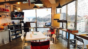 A modern workspace with a large table, chairs, and a TV screen.