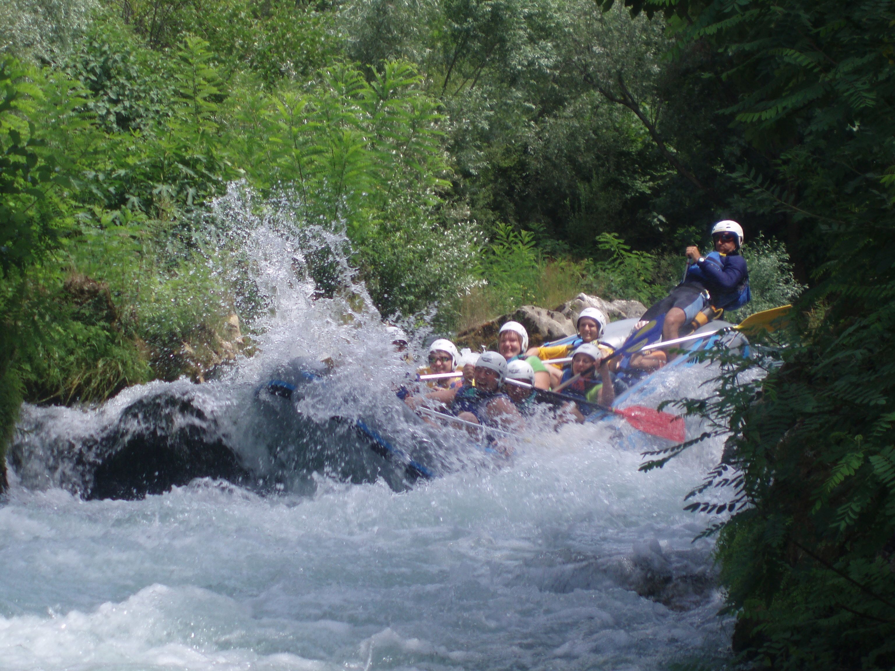 Un grupo de personas navegando en balsas por un río rodeado de vegetación densa.