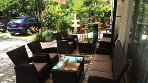 An outdoor seating area with wicker furniture and a stone floor. - Pansion Begić (Dugi Rat)