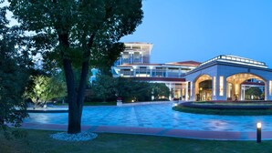 A modern hotel with a central courtyard, large arched entrance, and a flagpole. - Jinji Lake Grand Hotel (Suzhou)