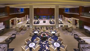A spacious lobby with multiple seating areas, a central decorative feature, and a view of the lobby area in the background. - Jinji Lake Grand Hotel (Suzhou)