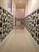 A hallway with patterned wallpaper and a radiator.