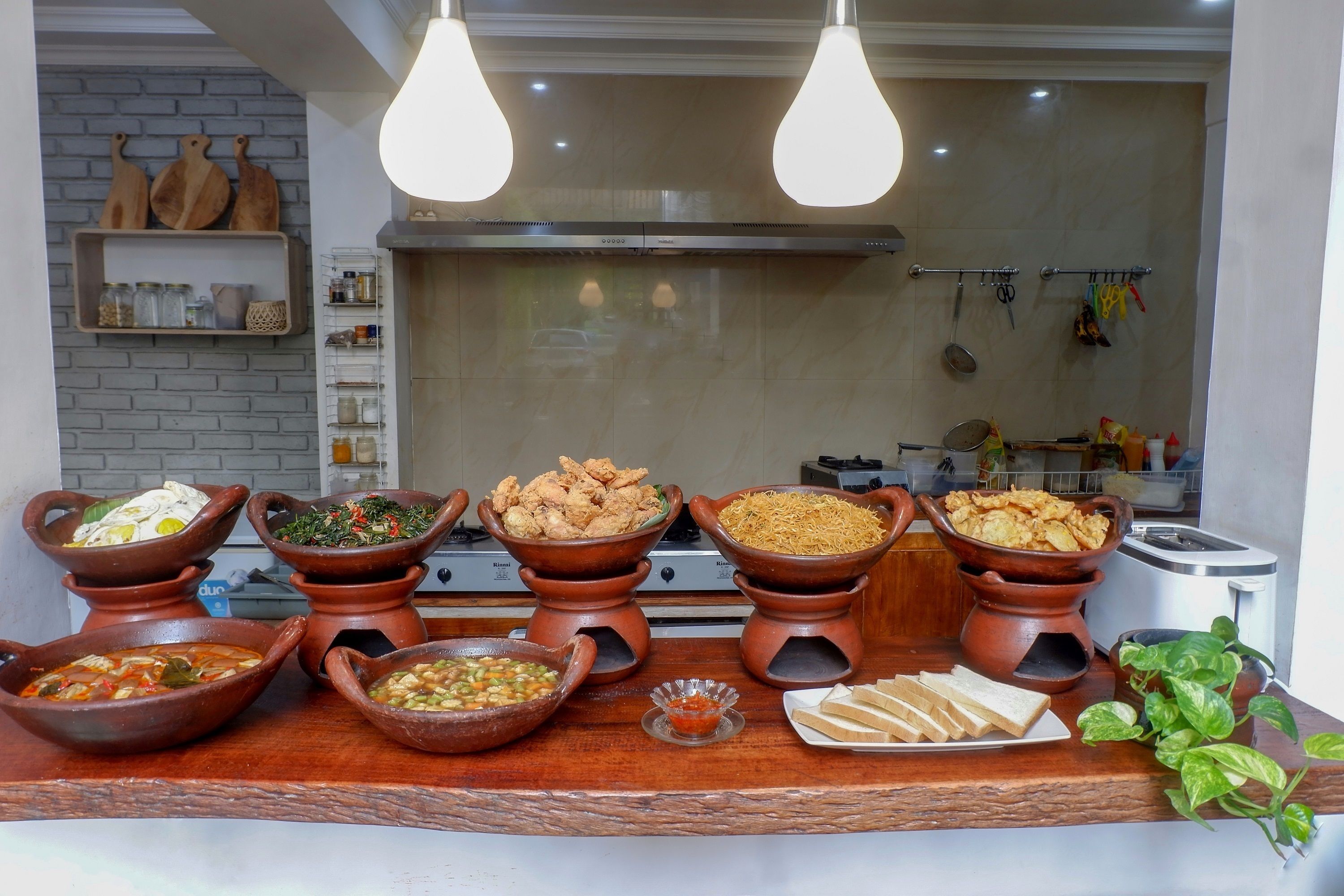 A buffet with various dishes and a kitchen in the background.