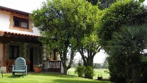 A house with a patio, a lawn, and a chair. - Casas Rurales El Terrero (Valdaliga)