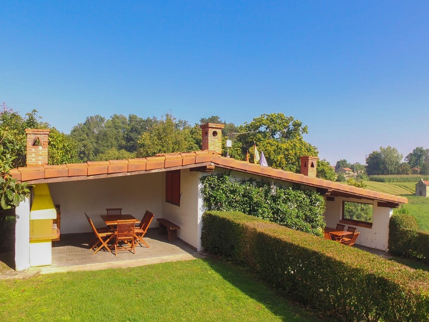 Una casa amb un pati, una taula de dinar i caires.
