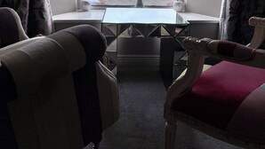 Une pièce avec vue sur l’océan, donnant sur celle-ci grâce à une grande fenêtre, et comprenant une petite table et deux chaises.