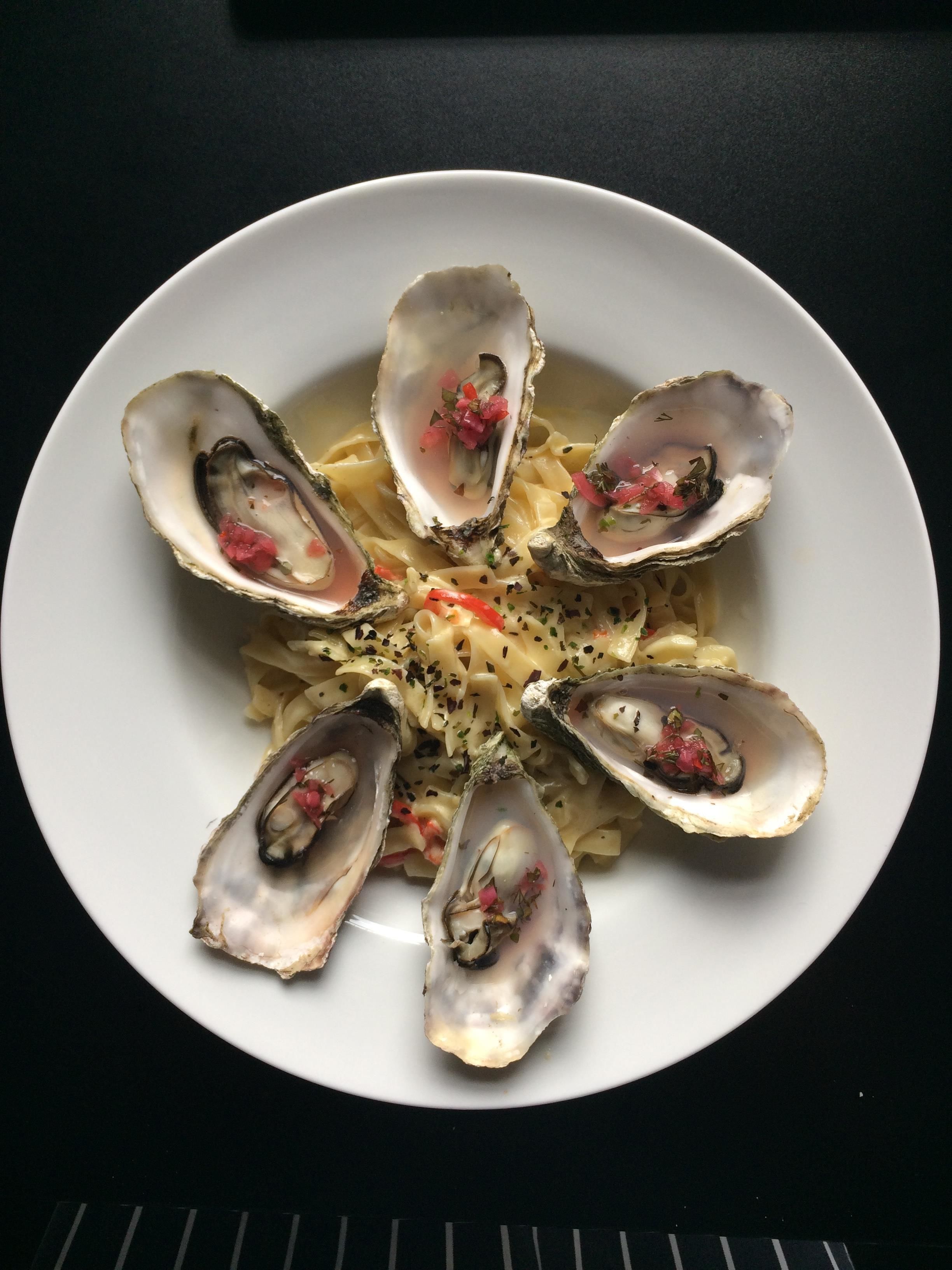 Un plato de pasta con ostras dispuestas en forma de flor.