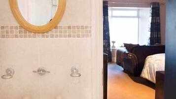 Une salle de bain équipée d’un lavabo, d’un miroir et de deux distributeurs de serviettes.