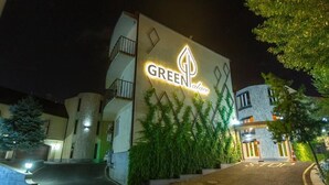 Un edificio con un cartello che riporta la scritta "GREEN Palace" e un segnale "STOP" all'ingresso.