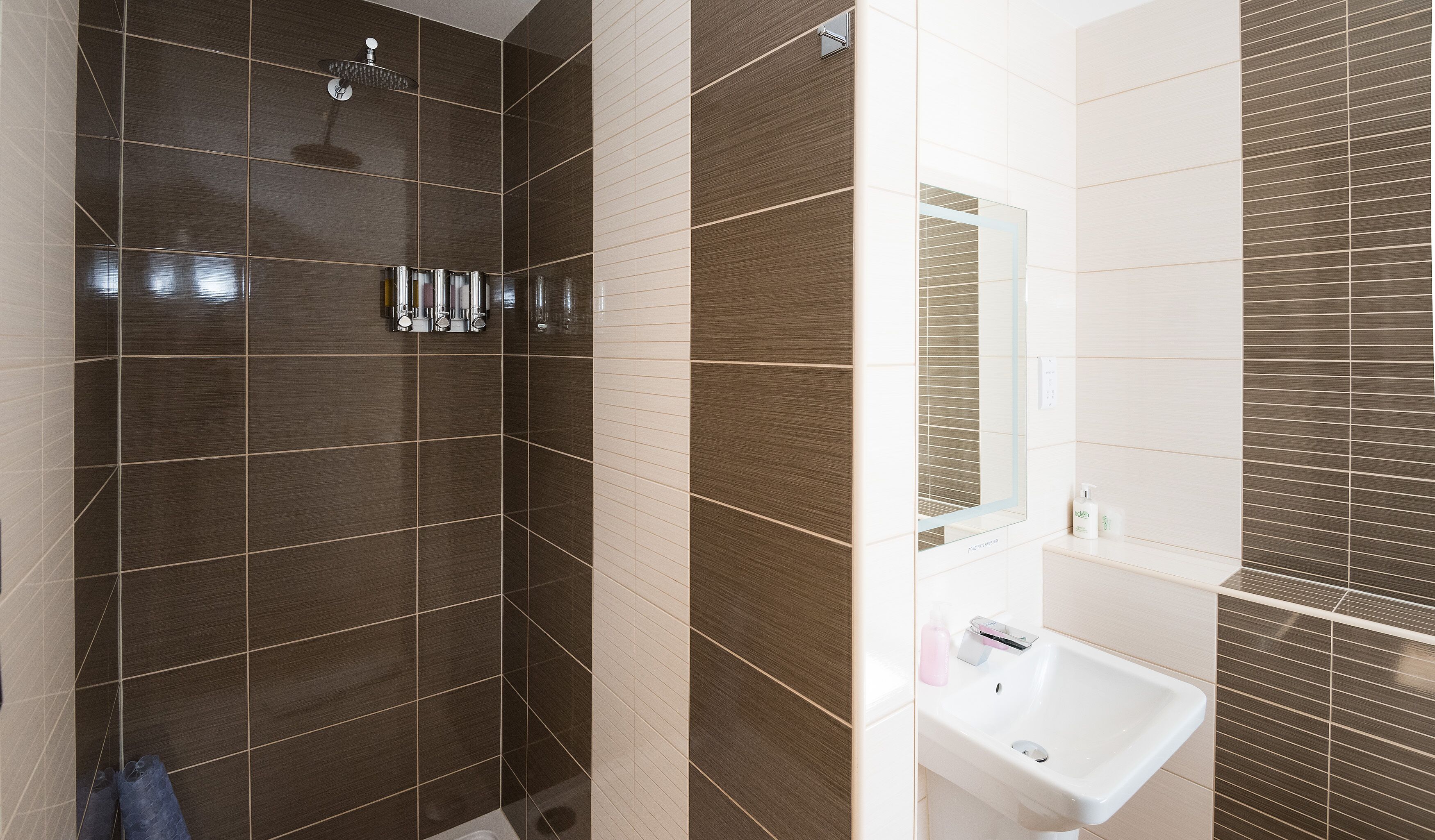 A bathroom with a shower, a sink, and a mirror.