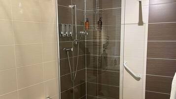 Un baño moderno con ducha de vidrio, inodoro y perchero para toallas.