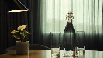 A table with a candle, a bottle, and two glasses.