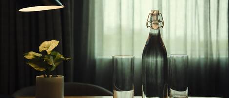 A table with a candle, a bottle, and two glasses.