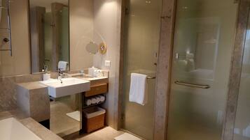 A modern bathroom with a glass-enclosed shower, a large sink, and a mirror.