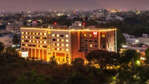 A modern hotel with multiple floors, a prominent 'W' logo, and a rooftop terrace.